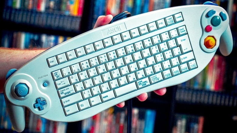 Controle de Nintendo GameCube esticado com um teclado de computador completo no meio